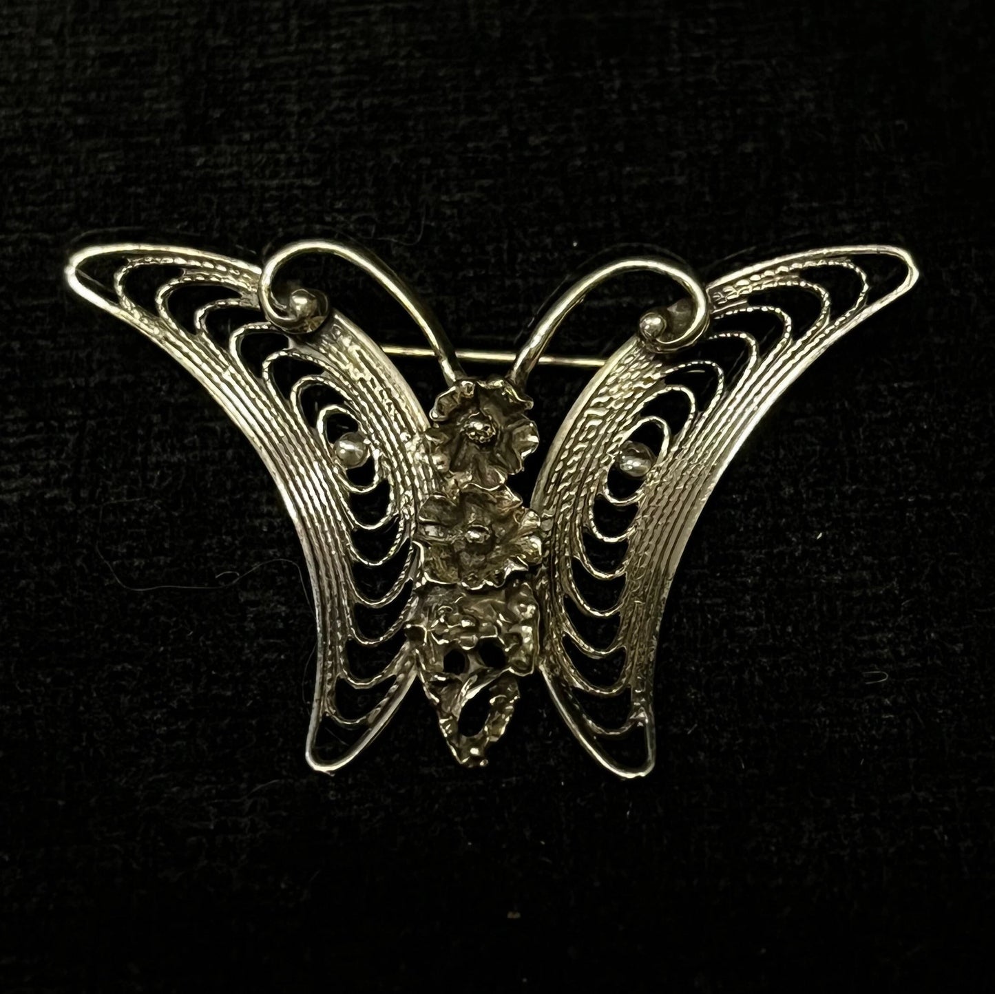 Butterfly brooch with intricate design on a black background