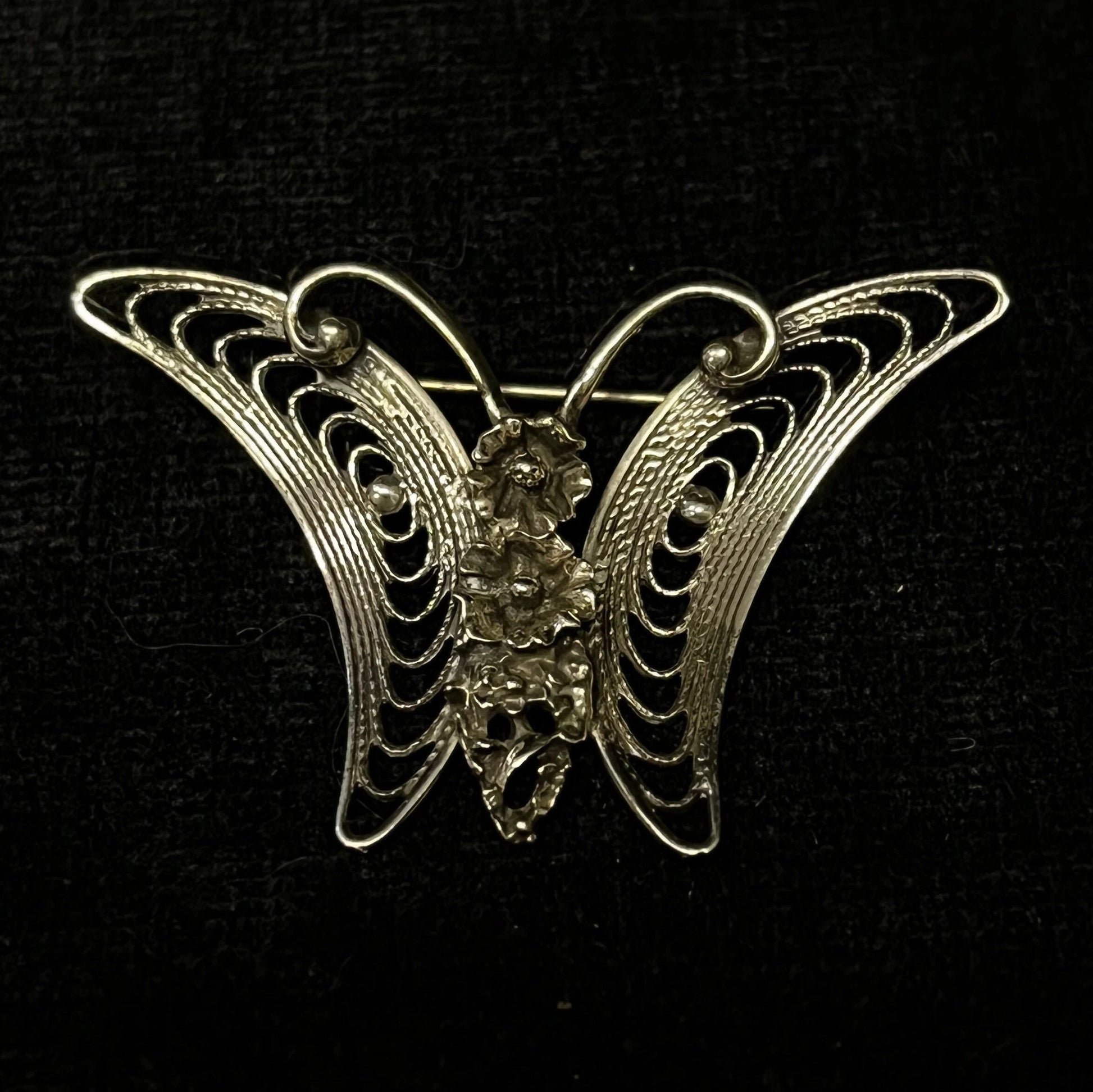 Butterfly brooch with intricate design on a black background