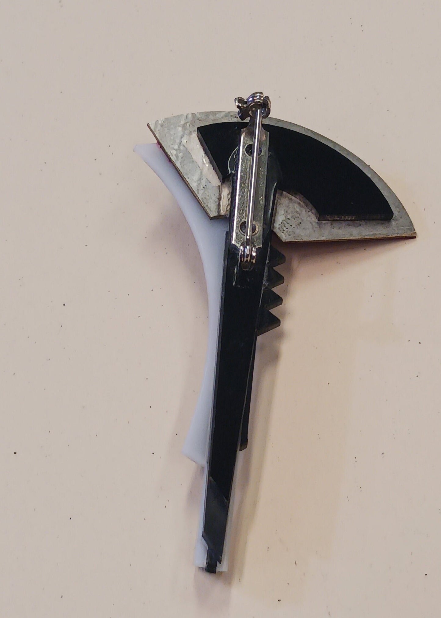 Back view of brooch on a light beige background
