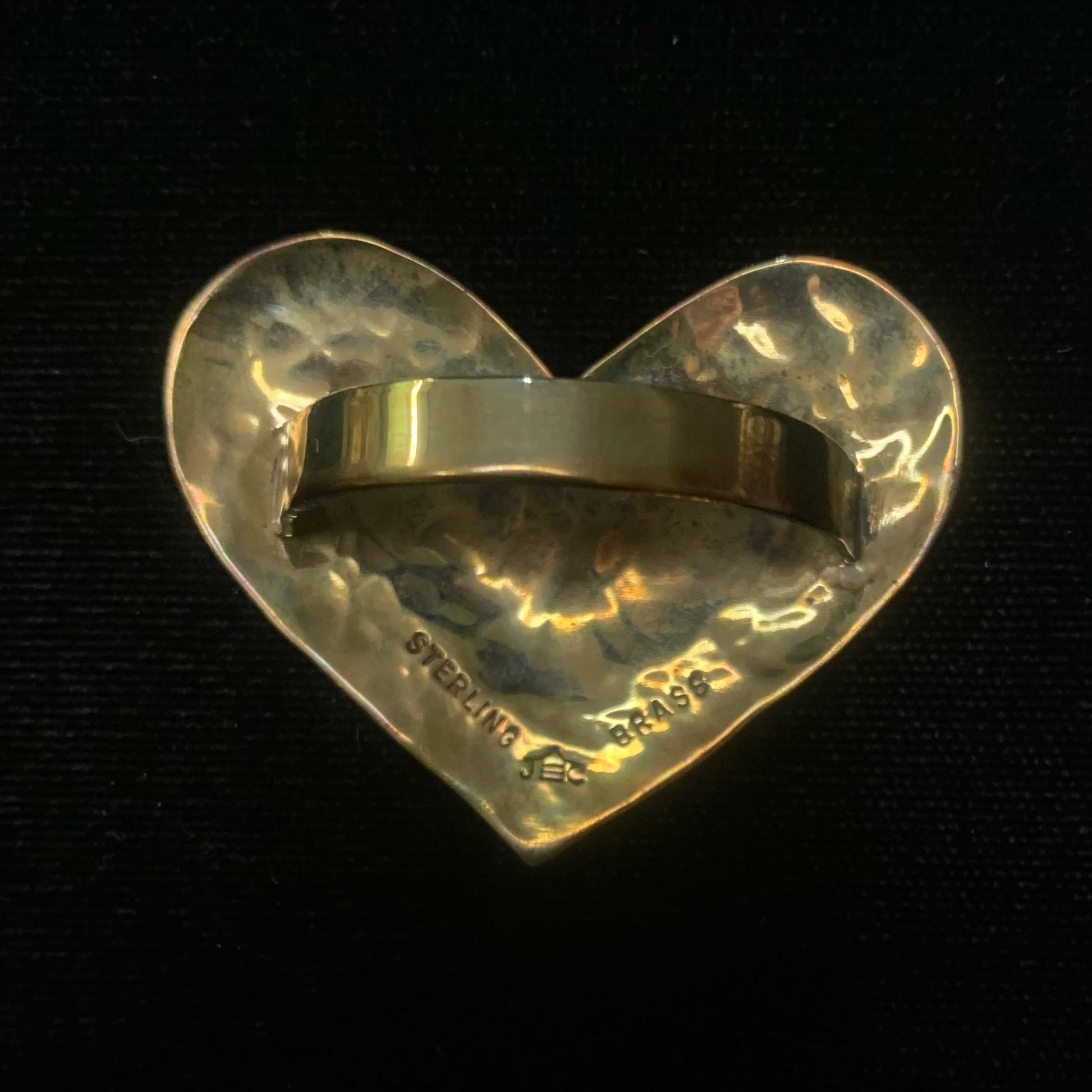 Heart-shaped scarf tie with 'STERLING' engraving on a black background