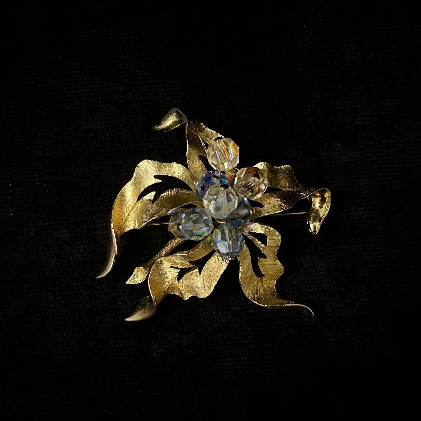 Gold brooch with gemstones on a black background