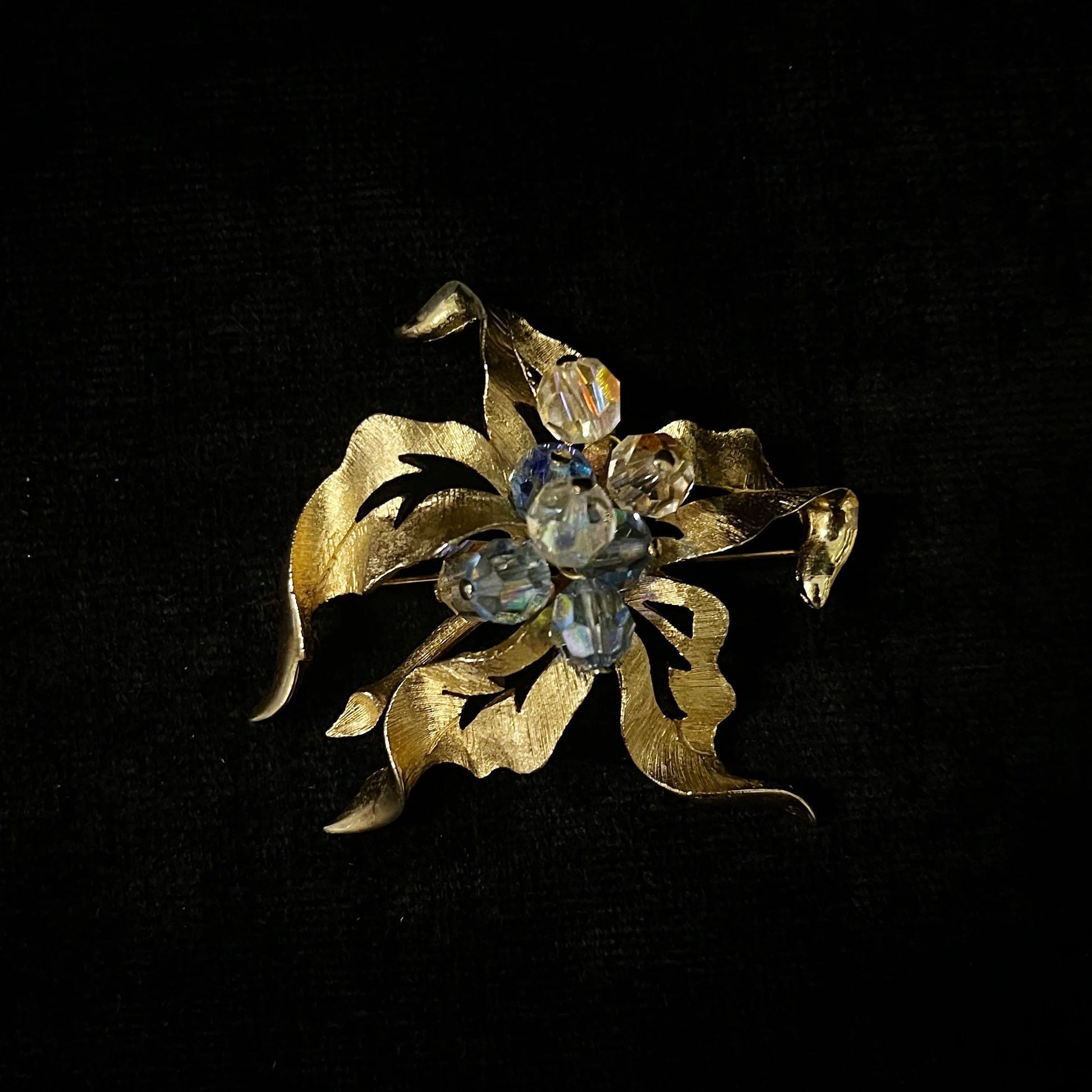 Gold brooch with gemstones on a black background