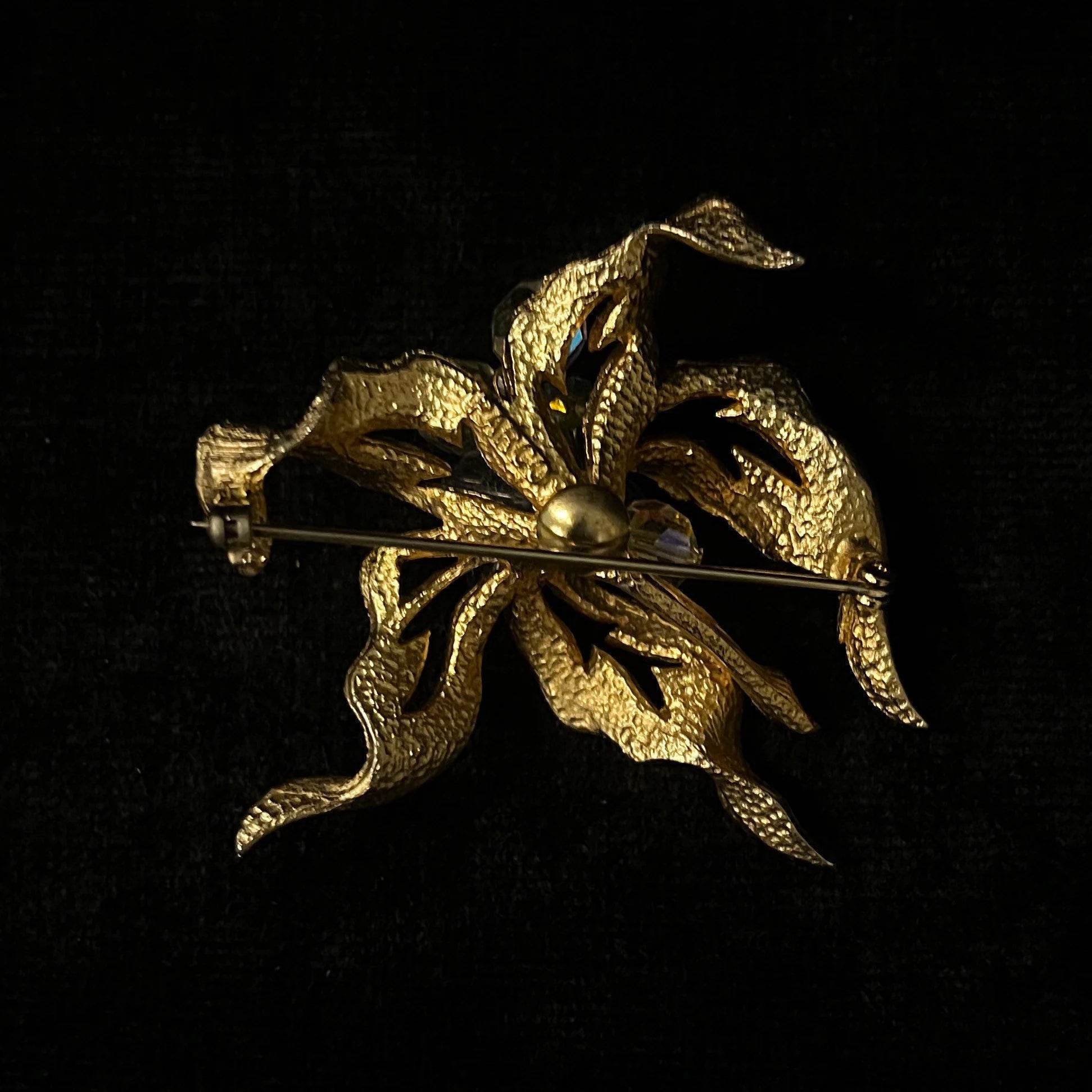 Gold leaf-shaped brooch on a black background