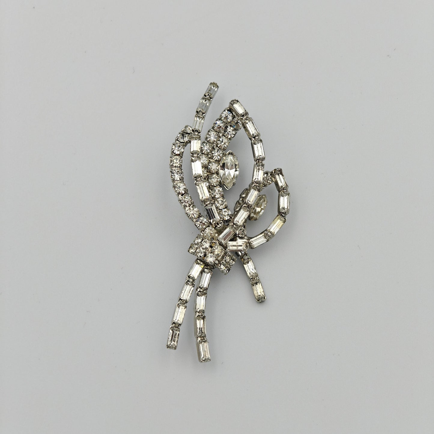 Silver brooch with gemstones on a gray background