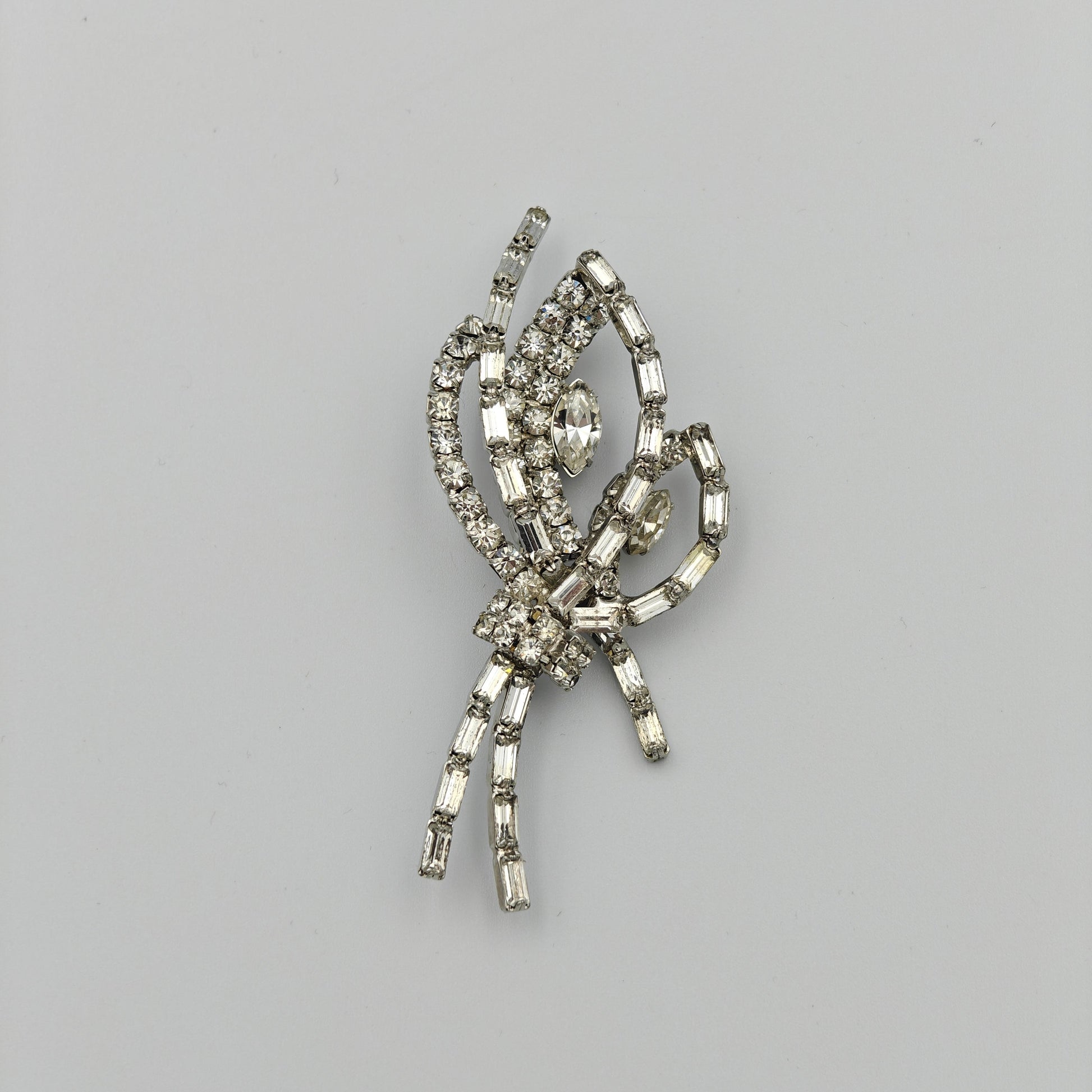 Silver brooch with gemstones on a gray background