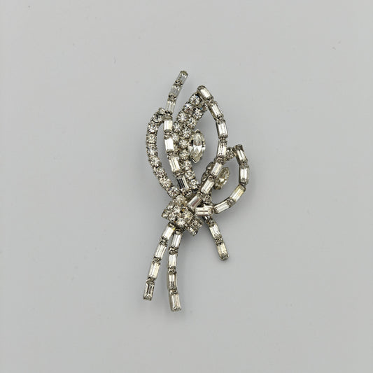 Silver brooch with gemstones on a gray background