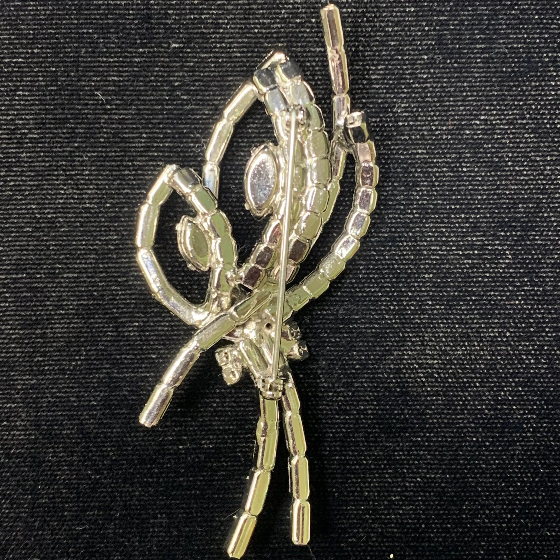 Silver brooch on a black background