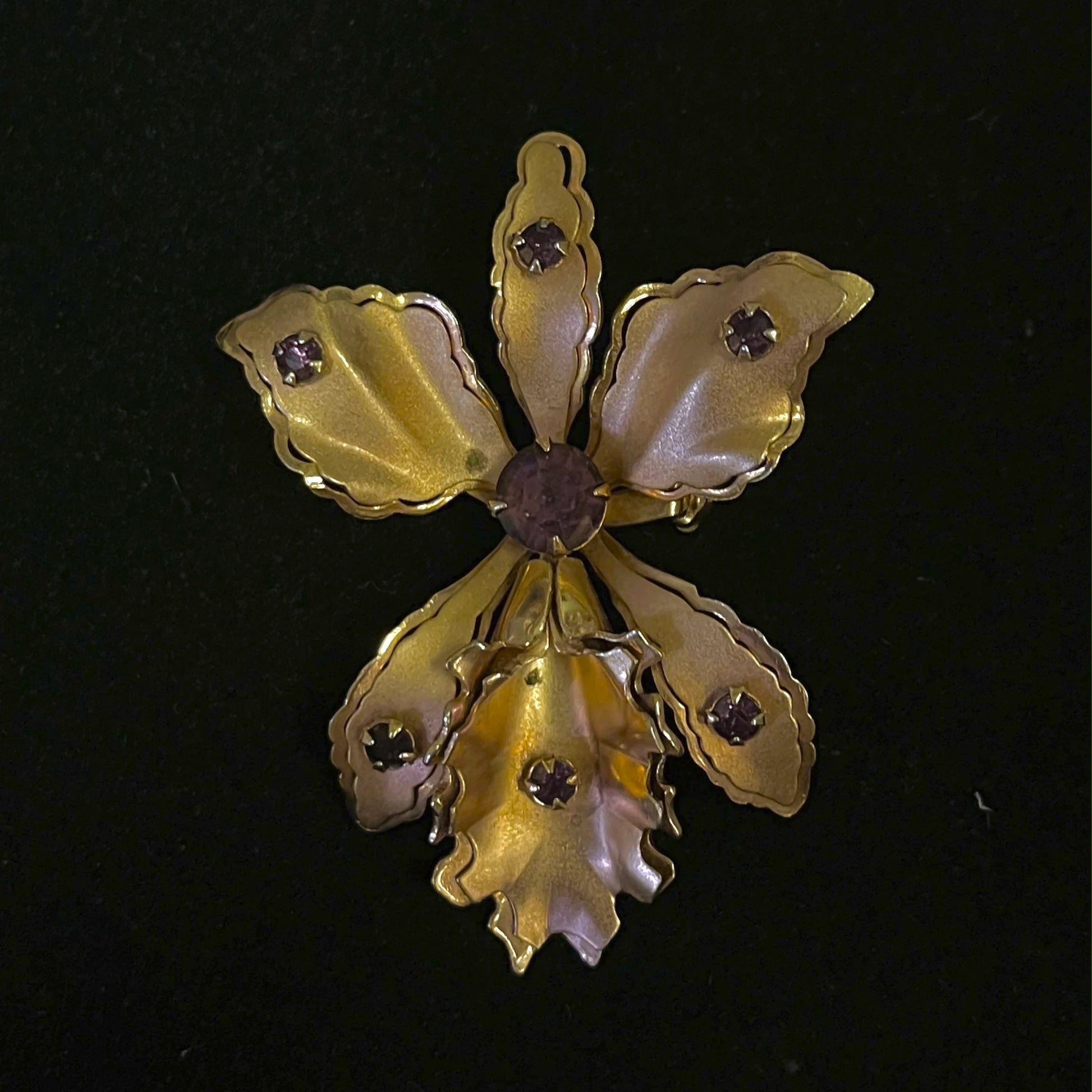 Gold brooch with gemstones on a black background