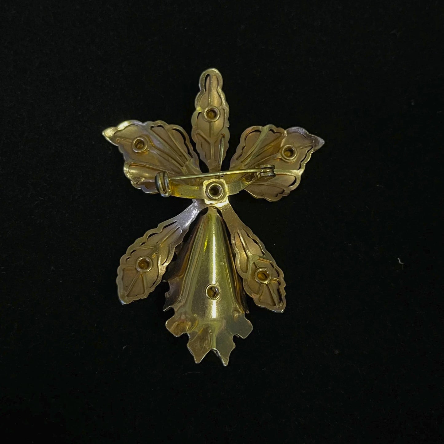 Gold flower-shaped brooch on a black background