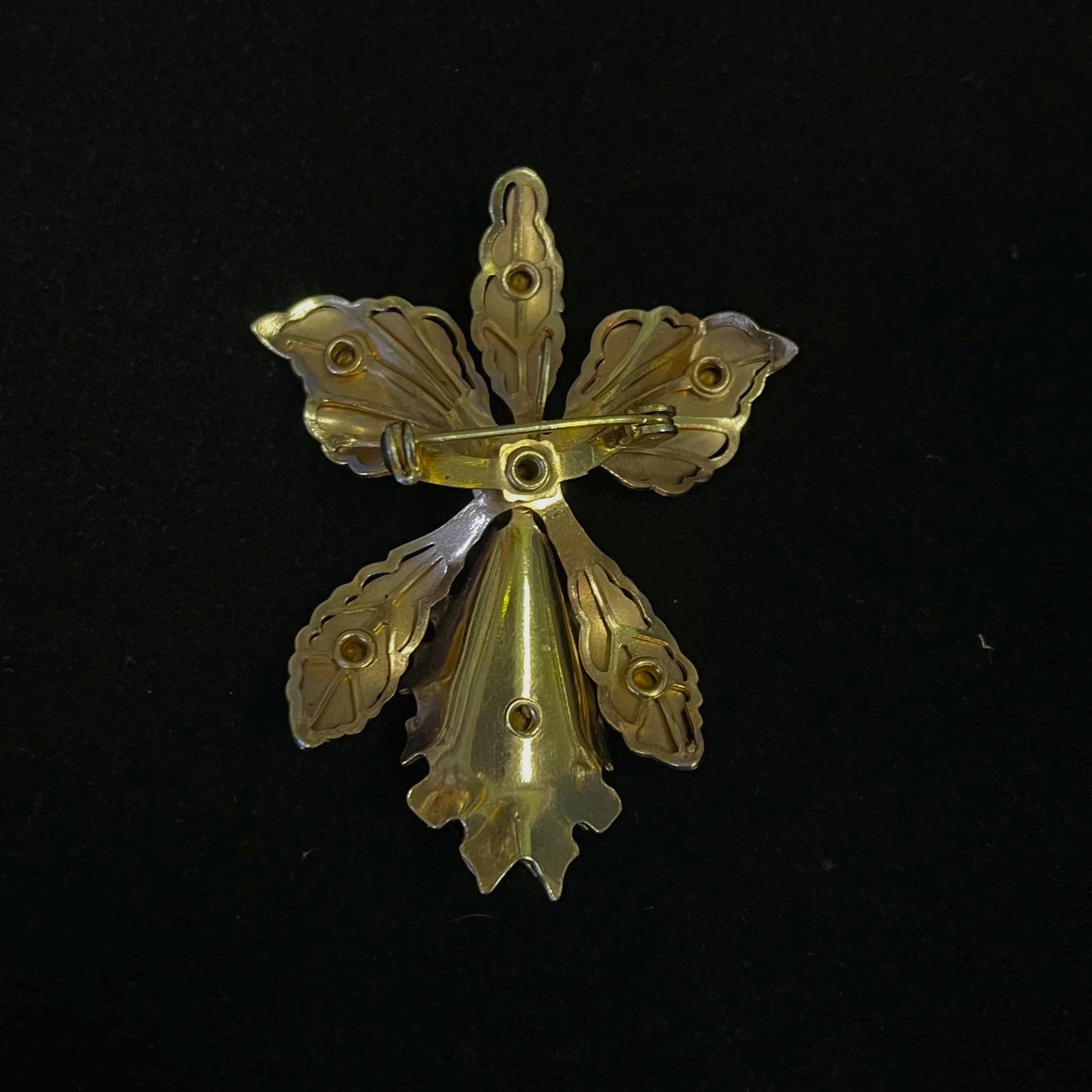 Gold flower-shaped brooch on a black background